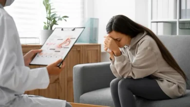 A lady with the doctor with her hands on her head